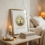 Inner Light tree wall art framed on a wooden bedside table with a linen covered bed in the background, soft candle light and 3 linen notebooks infront of the image with a gold frame around it, a candle and a clear quartz crystal. 