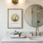 Sacred geometry tree art print displayed in a vintage bathroom with dark gold accents, a round mirror and marble sing top. 
