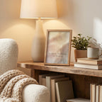 A warm, cozy interior scene with a lit table lamp, a framed art print with the quote 'No forcing. Not resisting.